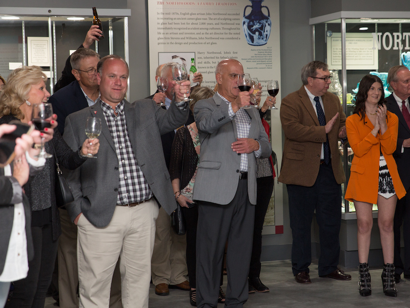 A group of people raise their glasses to toast at Oglebay Institute's Glass Museum. 